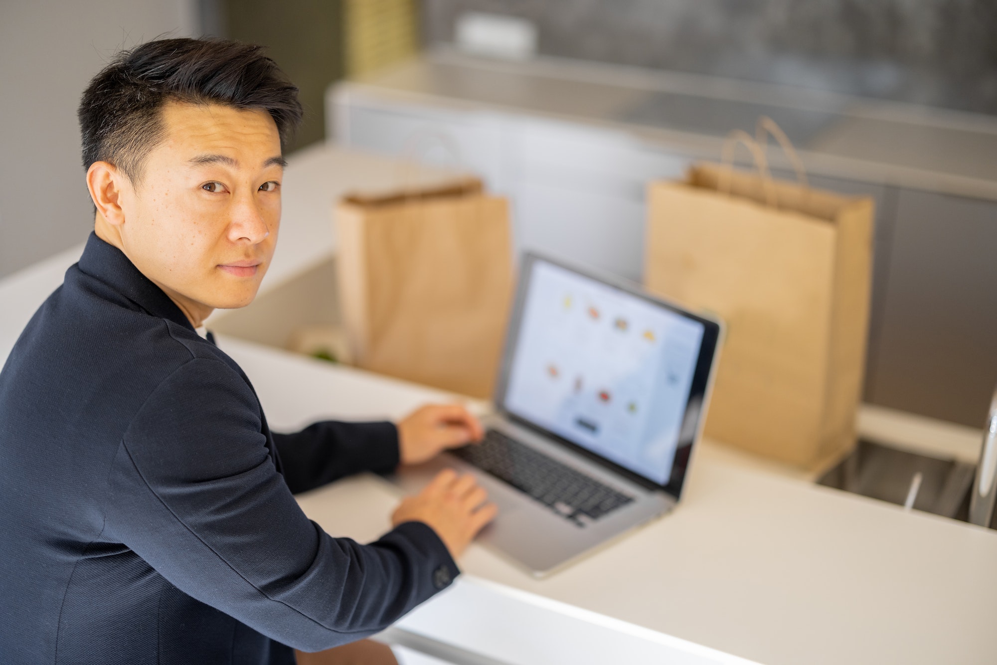Man choosing groceries in online store on laptop